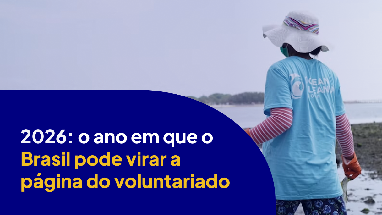 Voluntária de costas em ação de limpeza de praia, com chapéu e camiseta de organização ambiental, representando o Ano Internacional do Voluntariado 2026